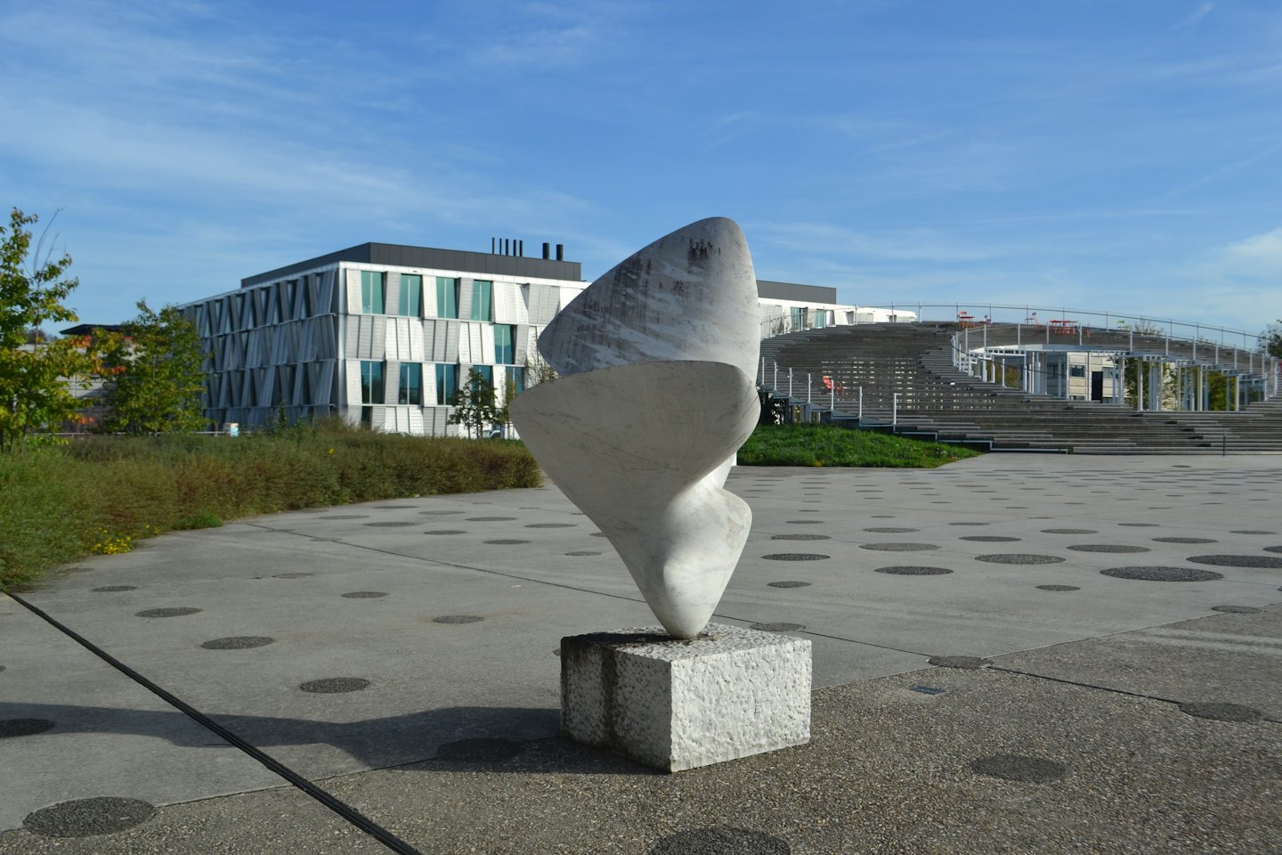 White abstract sculpture in a modern urban plaza.